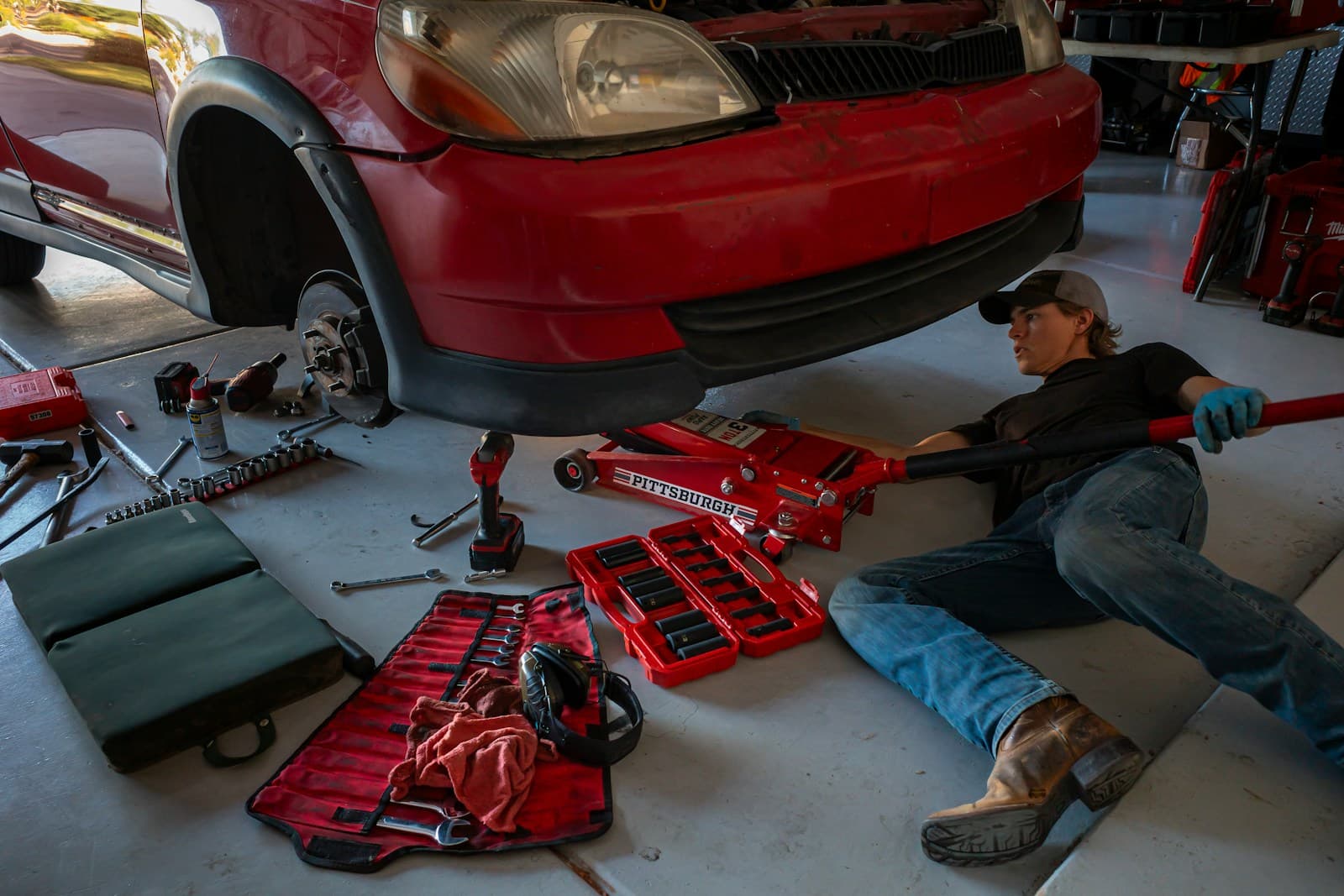 A mechanic working on a vehicle in a repair bay — representing the auto shop workflows Founder's Point automates with customer status updates and parts tracking.
