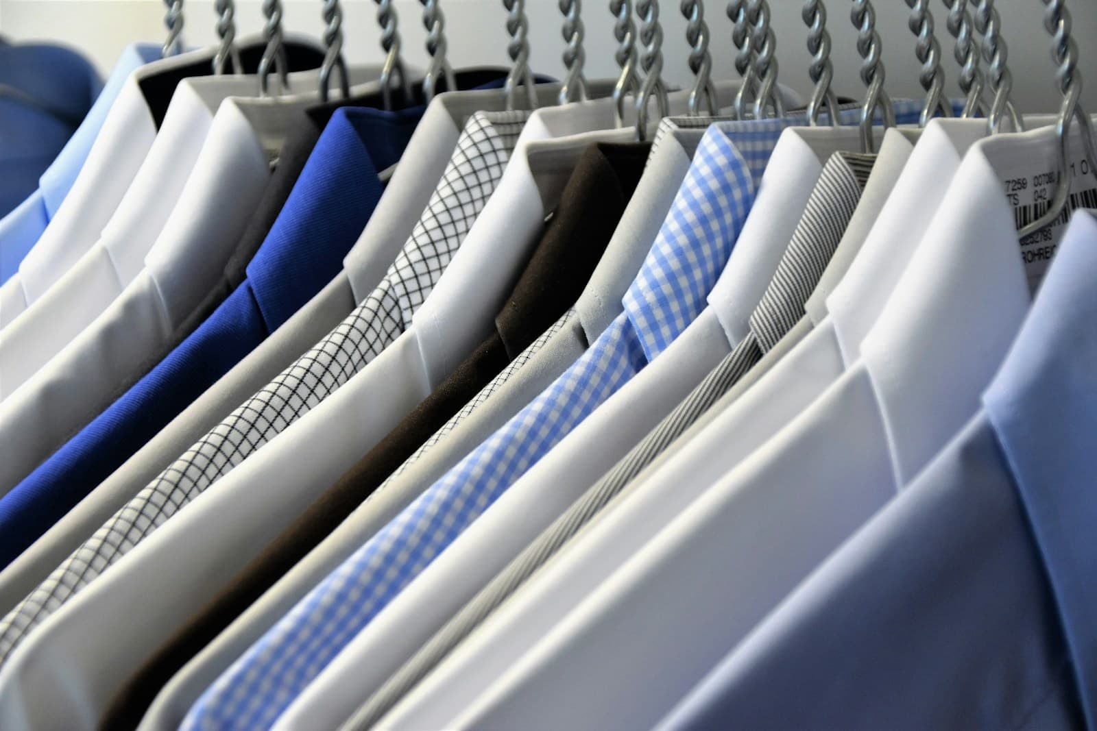 Dress shirts on hangers in a commercial dry cleaning operation — the kind of workflow Founder's Point automates for dry cleaners.